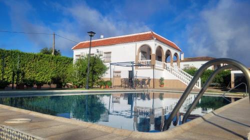 a house with a swimming pool and a building at Los Candiles in Cantillana