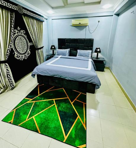a bedroom with a bed and a green rug at Den in Rawalpindi