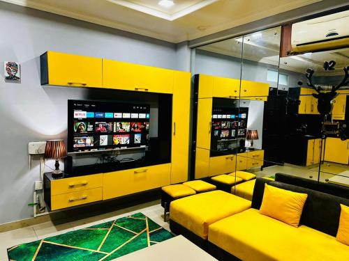 a control room with a yellow couch and a television at Den in Rawalpindi