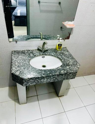 a bathroom counter with a sink and a mirror at Den in Rawalpindi