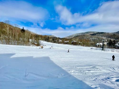 a group of people skiing down a snow covered slope at Ski-in, ski-out chaleureux studio loft au pied des pistes de ski in Stoneham