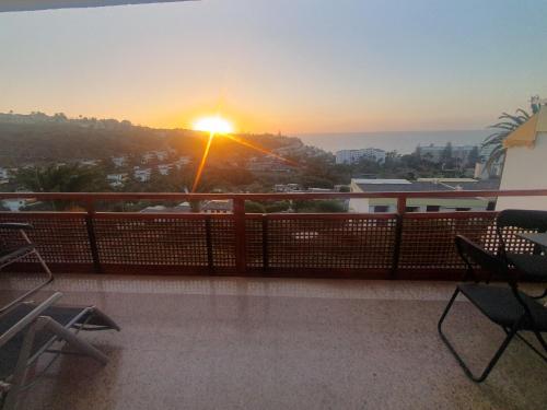 einen Blick auf den Sonnenuntergang vom Balkon eines Gebäudes in der Unterkunft Casa panorama 314 San Agustín Maspalomas in San Agustín