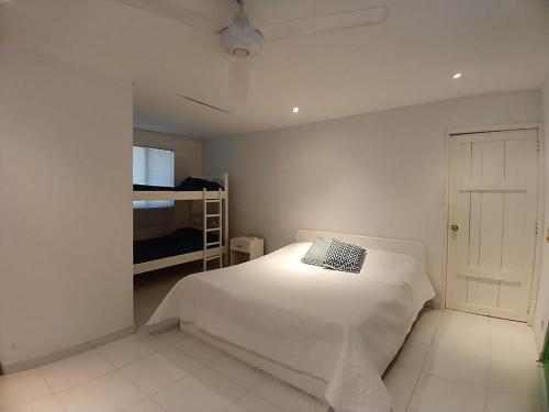 1 dormitorio blanco con 1 cama y 1 litera en Isla Tortuga - Prado - Deportes Náuticos - Cerca a Bogotá - Cerca a Ibagué, en Prado