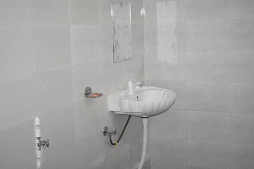 a white bathroom with a sink and a shower at MANAS RAY HOMESTAY in Jyoti Gaon