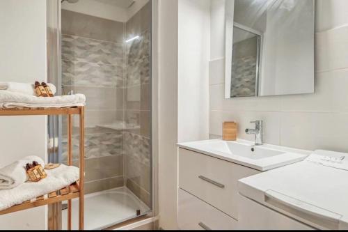 uma casa de banho branca com um chuveiro e um lavatório. em Joli T2 - domaine de la Coudouliere - Piscine em Six-Fours-les-Plages