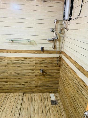 La salle de bains est pourvue d'une douche et d'un mur en bois. dans l'établissement Villa Binna, à Galle
