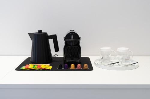 a black coffee maker on a counter with glasses at InSogno Suites in Naples
