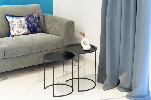 a living room with two tables in front of a couch at InSogno Suites in Naples
