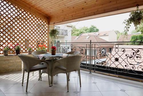 Un patio con una mesa y sillas en un balcón. en Zemun Center LUX 3 bedroom, en Belgrado