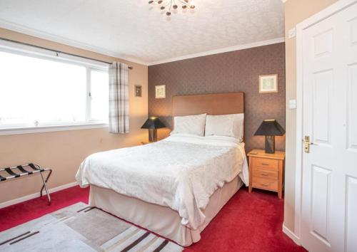 ein Schlafzimmer mit einem großen Bett und einem Fenster in der Unterkunft Fonthill Bed and Breakfast Nairn in Nairn