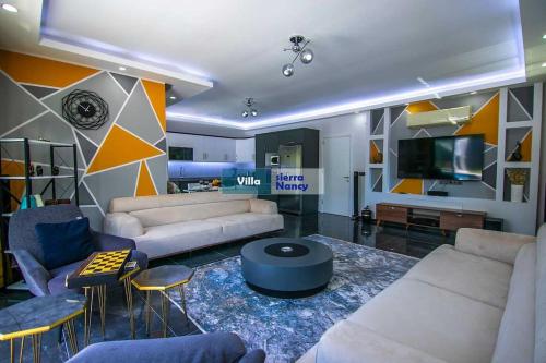 a living room with two couches and a tv at Tam korunaklı villa 'Kayaköy' in Fethiye