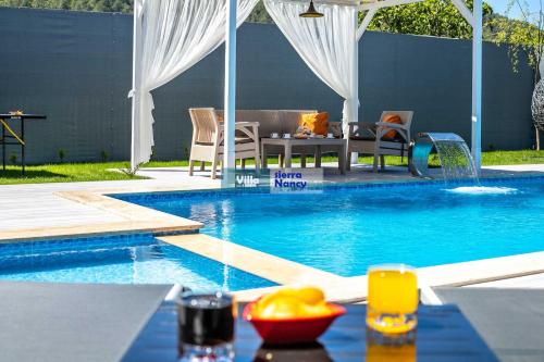 a swimming pool with a table and chairs and a swimming pool at Tam korunaklı villa 'Kayaköy' in Fethiye