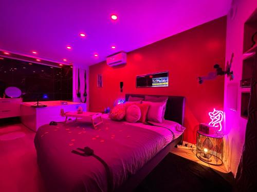 a bedroom with pink lighting and a bed in a room at MJ Lust Room, centre var proche Verdon, cotignac, ambiance romantique in Montfort-sur-Argens