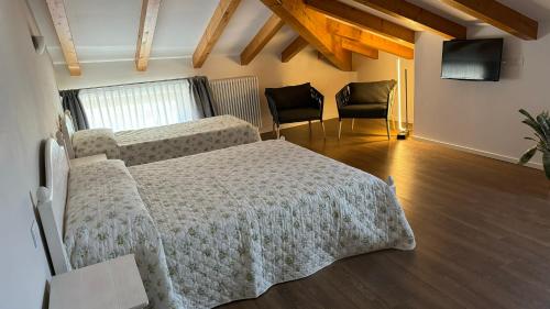 a bedroom with a bed and two chairs at Agritur La Pieve in Taio