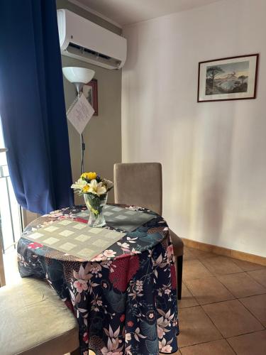 una mesa con un jarrón de flores encima en The Romantic House, en Nápoles