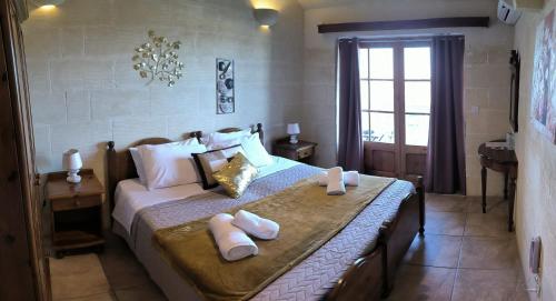 a bedroom with a bed with towels on it at Il figolla b&b in Xagħra