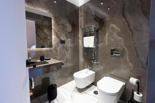 a bathroom with a toilet and a sink at InSogno Suites in Naples