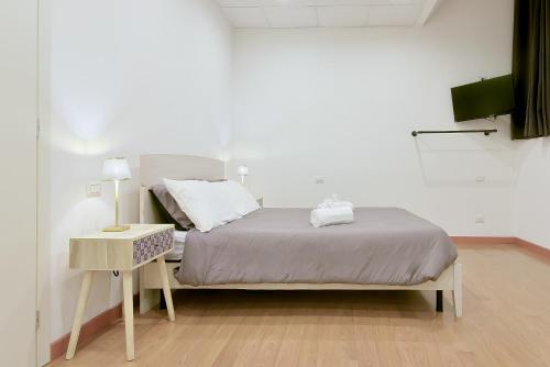 a bedroom with a bed and a table with a lamp at LHE Les Trois Merveilles in Cesena