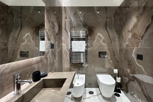 a bathroom with a sink and a toilet in it at InSogno Suites in Naples