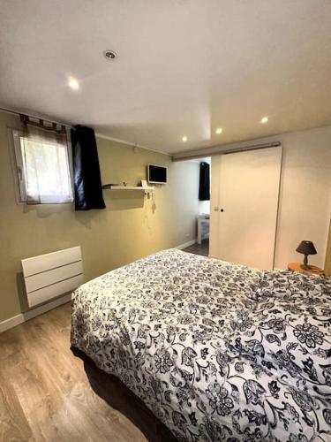 1 dormitorio con 1 cama con manta blanca y negra en logement pour séjourner en Aix-en-Provence