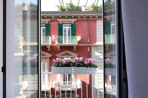 a window with a pot of flowers on a balcony at InSogno Suites in Naples