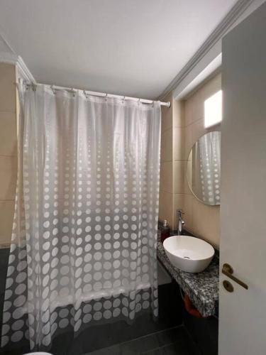 een badkamer met een douchegordijn en een wastafel bij erental.arg departamento centro in Cordoba