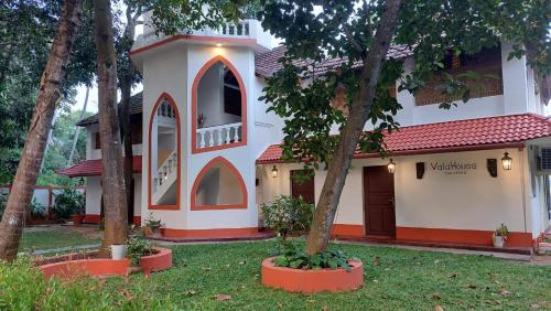 a house with trees in front of it at Vala House in Cherai Beach