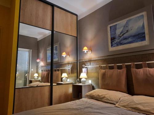 カリー・ル・ルエにあるLe Paradis Bleuのベッドルーム(大きな鏡、ベッド付)