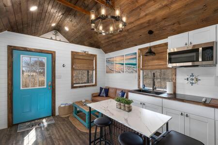 a kitchen with a table and a blue door at Life's a Beach - 3 Acres with Hot Tub in Fredericksburg