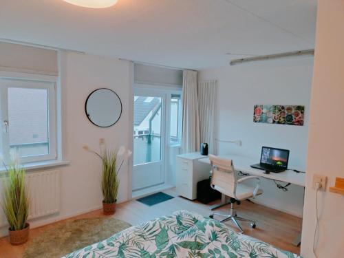 een slaapkamer met een bed, een bureau en een computer bij Holiday Home 't Groene Hart in Alphen aan den Rijn