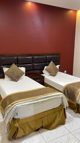2 Betten nebeneinander in einem Zimmer in der Unterkunft اجنحة الازدهار للوحدات السكنية in Rafha