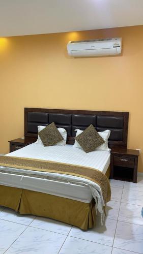una camera da letto con un grande letto e un condizionatore a muro di اجنحة الازدهار للوحدات السكنية a Rafha