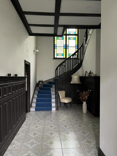 a hallway with a staircase with blue carpeted floors at Apartmánový dům Jánský sen in Janske Lazne
