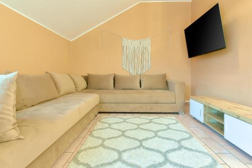 a living room with a couch and a flat screen tv at LHE Central View Boutique in Cesena