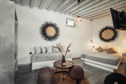 een slaapkamer met een bed, een tafel en 2 spiegels bij Firistefana Apartment in Serifos Chora