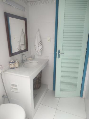 y baño con lavabo, espejo y aseo. en Chalé em Itaocaia Valley Itaipuaçu Maricá RJ, en Maricá