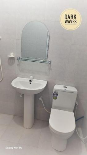 a bathroom with a sink and a toilet and a mirror at Dark waves villa in Nilaveli
