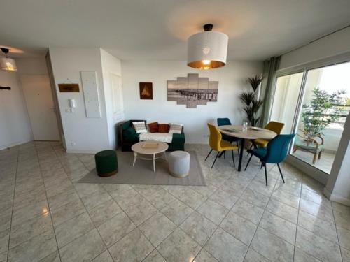 un salon avec un canapé, une table et des chaises dans l'établissement Ref 121 - Bel appartement moderne avec vue mer et port Crouesty pour quatre personnes, à Arzon