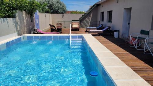 una piscina con terraza de madera y una piscina en Manantiales Hotel Boutique en Victoria