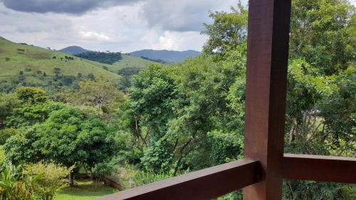 a window view of a valley with trees and mountains at Pousada Castelinho Conservatória in Conservatória