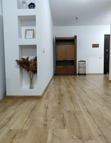 pusty pokój z wazą na drewnianej podłodze w obiekcie Apartament in Ialoveni la 5 km de Chisinau w mieście Ialoveni