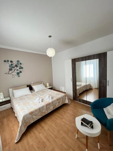 a bedroom with a large bed and a blue chair at Darlen in Rabac