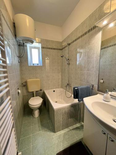 een badkamer met een toilet, een bad en een wastafel bij Darlen in Rabac