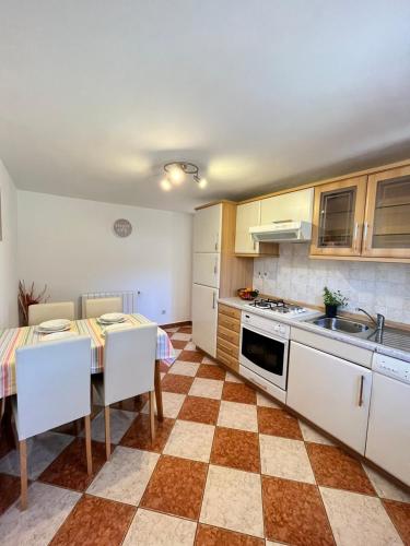 a kitchen with a table and chairs and a kitchen with a stove at Darlen in Rabac