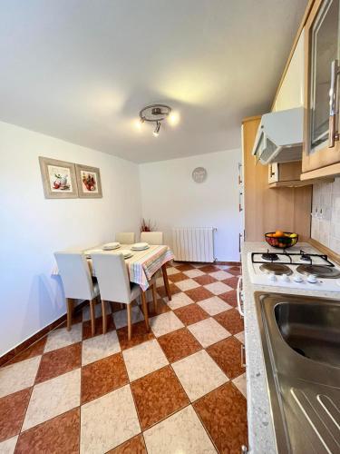 uma cozinha com mesa e cadeiras e uma cozinha com fogão em Darlen em Rabac