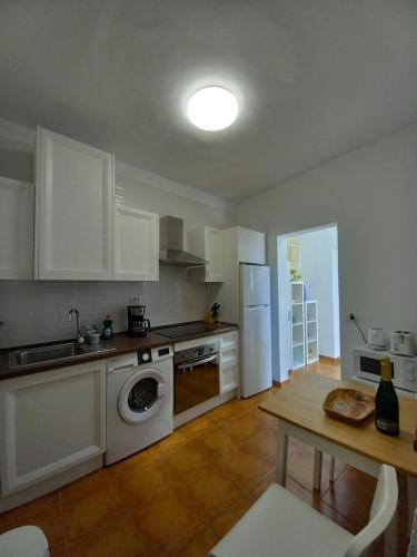 uma cozinha com electrodomésticos brancos e uma mesa com uma mesa em CASA ISABEL - (ZONA RURAL) em Fasnia