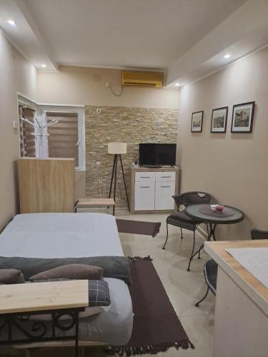 a bedroom with a bed and a table and a tv at Golden Star Viktor in Zaječar