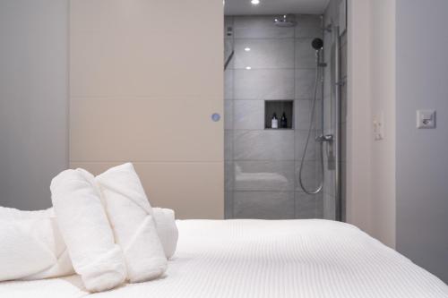 Cama blanca con almohadas blancas y ducha en LOFT am See - dein Zuhause direkt am Wasser - self checkin - Bitcoin accepted en Thun