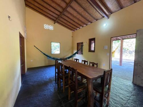 a dining room with a wooden table and chairs at Casa na lagoa azul in Cruz