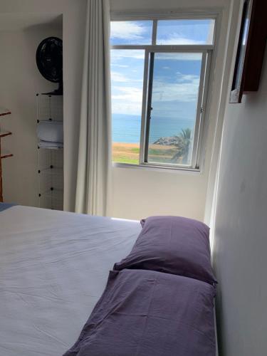 um quarto com uma cama e uma janela em Bela vista a beira mar em Marataízes